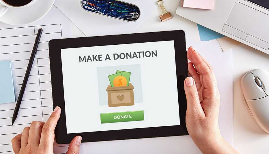 Manos sosteniendo una tableta que dice hacer una donación