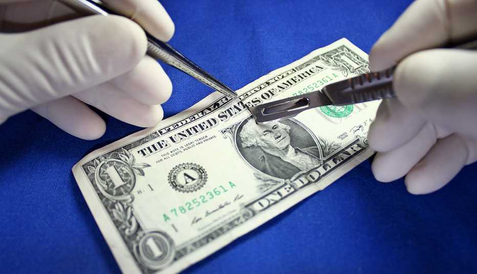 Manos examinando un billete de dólar