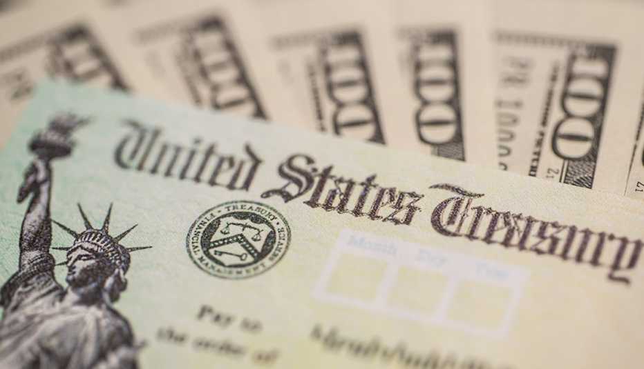 Cheques de estímulo alrededor de billetes de $100 dólares. Cheques de estímulo alrededor de billetes de $100 dólares.