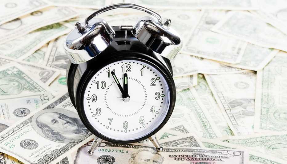 Reloj despertador sobre billetes de 100 dólares