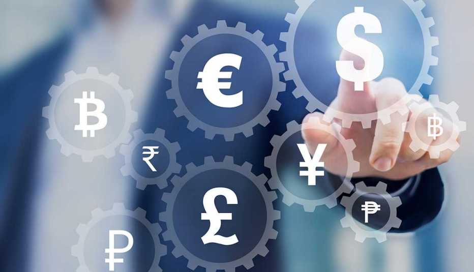 Mano de un hombre señalando el signo del dólar al lado de otras monedas del mundo
