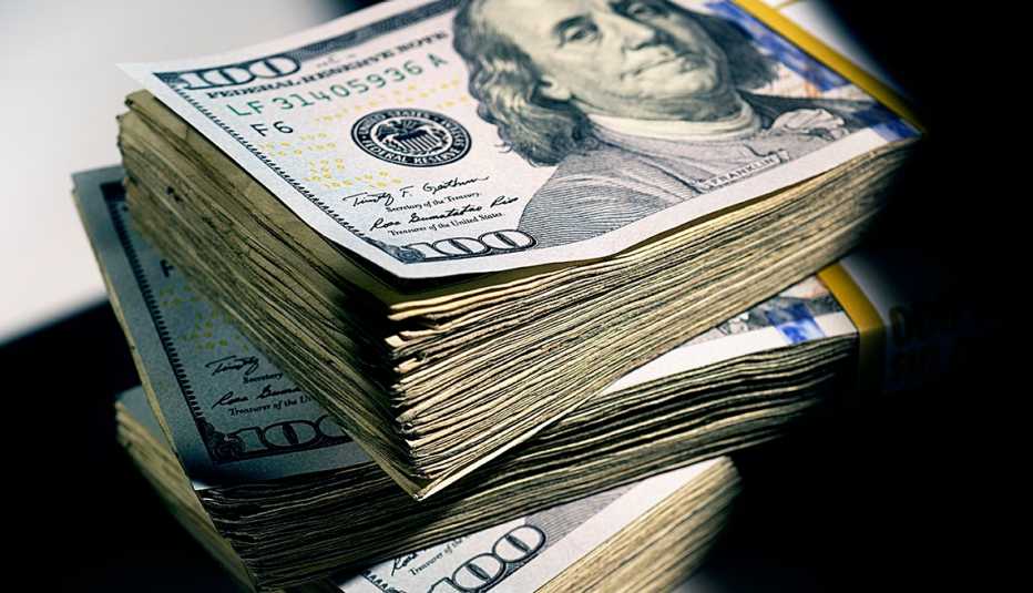Pila de dinero con billetes de $100.