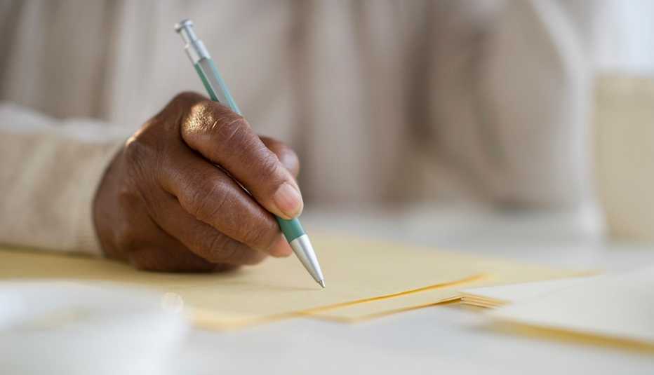 Mano escribiendo en una hoja