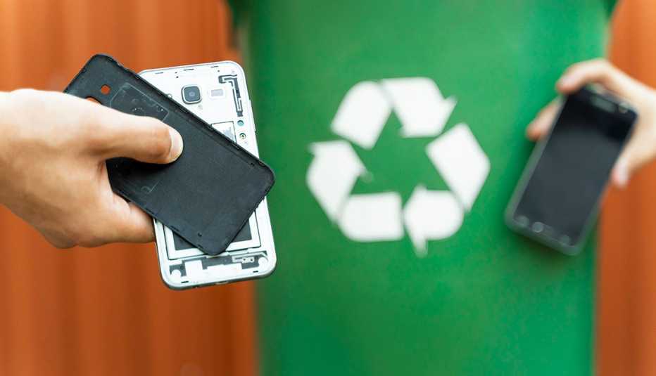 Dos teléfonos frente a un bote de reciclaje