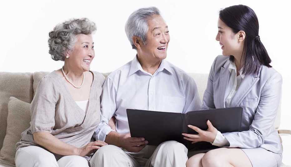 Pareja conversando con un vendedor de seguros - Formas de ahorrar en seguros Pareja conversando con un vendedor de seguros - Formas de ahorrar en seguros