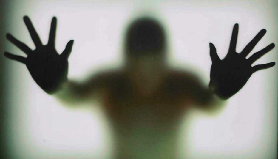 Manos de una persona apoyadas sobre un vidrio opaco - Becas universitarias inusuales