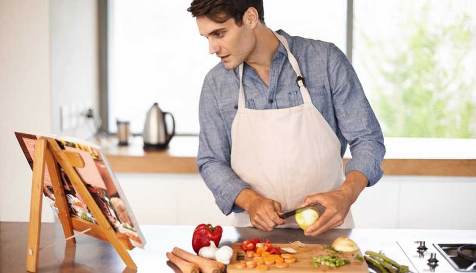 Hombre cocinando una receta de un libro - Becas universitarias inusuales