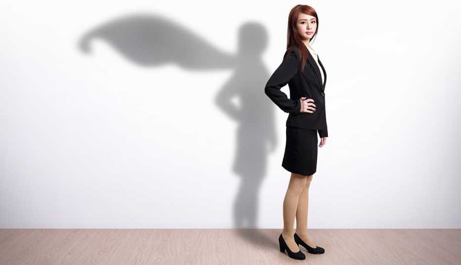 Joven vestida con traje de oficina con una sombra que tiene su figura y una capa voladora - Becas universitarias inusuales