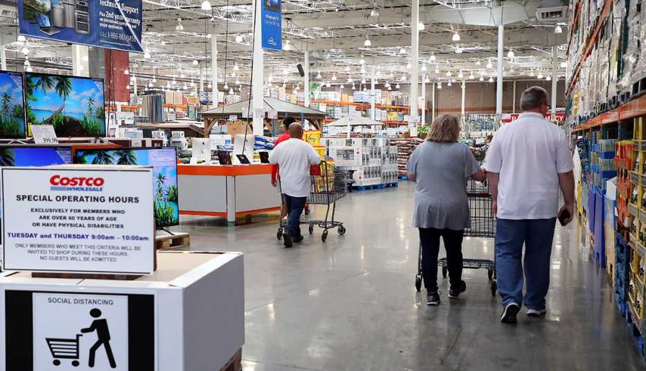 Un letrero dentro de la tienda Costco saluda a sus clientes durante la pandemia, recomienda el distanciamiento social y de los horarios para mayores de 60.