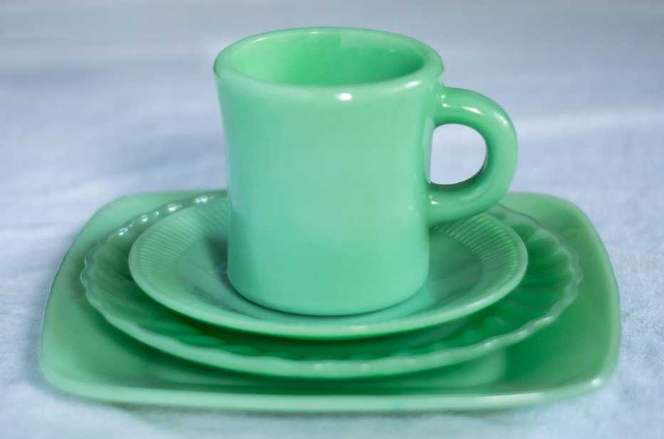 Taza de porcelana encima de varios platos pequeños
