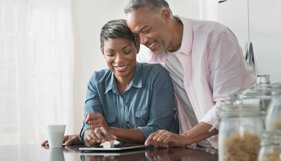 Pareja usando una tableta digital en una mesa de cocina