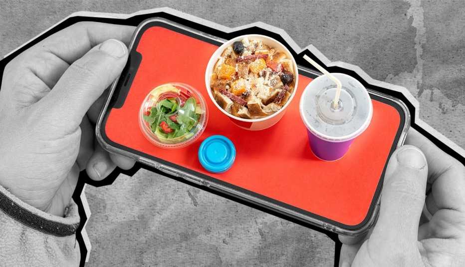 una mano sosteniendo un telefono con comida diminuta