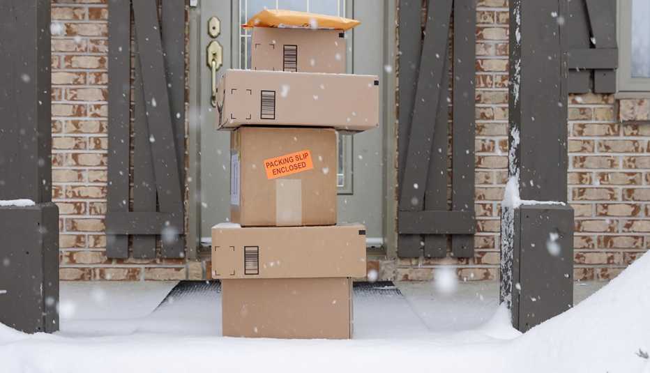 Cajas apiladas frente a una puerta y copos de nieve que caen del cielo