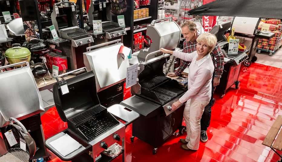 Pareja en una tienda viendo parrillas para asados