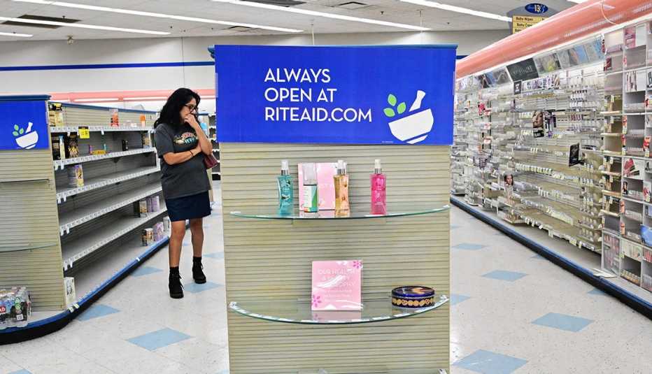 Una mujer examina los estantes casi vacíos en una tienda Rite Aid que cerrará después de que el minorista se declarara en quiebra en octubre de 2023. Una mujer examina los estantes casi vacíos en una tienda Rite Aid que cerrará.