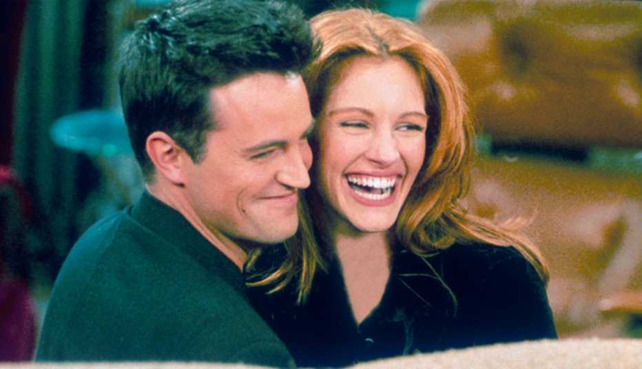 Matthew Perry y la actriz Julia Roberts se abrazan mientras filman la serie "Friends".