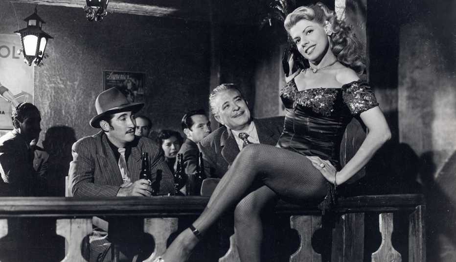 Imagen en blanco y negro de Ninón Sevilla y dos hombres mirádola