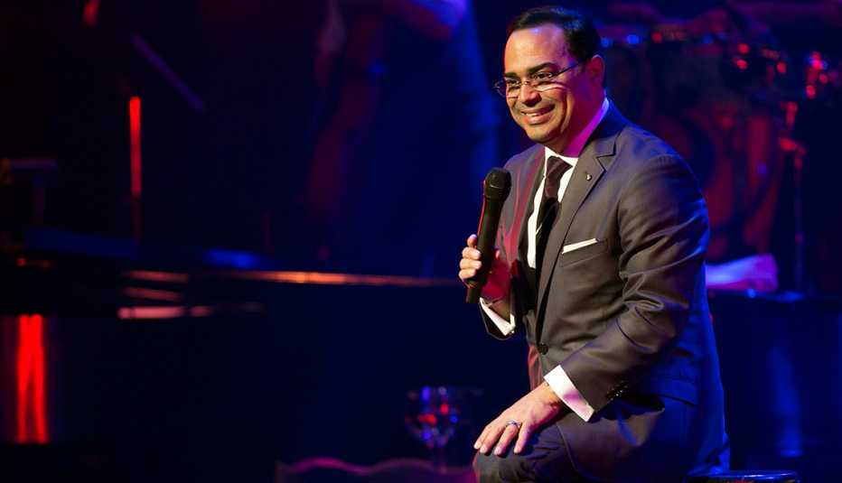Gilberto Santa Rosa sentado frente a un piano en un concierto Gilberto Santa Rosa sentado frente a un piano en un concierto