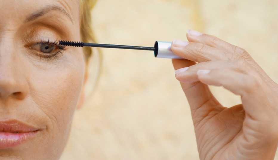 Mujer aplicando delineador sobre sus cejas. Mujer aplicando delineador sobre sus cejas.