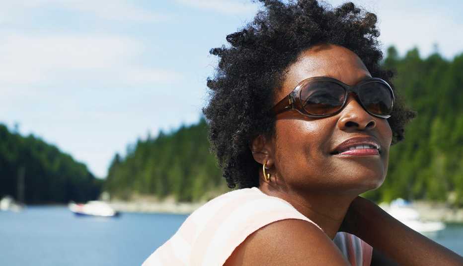 Mujer usando gafas frente a un lago.