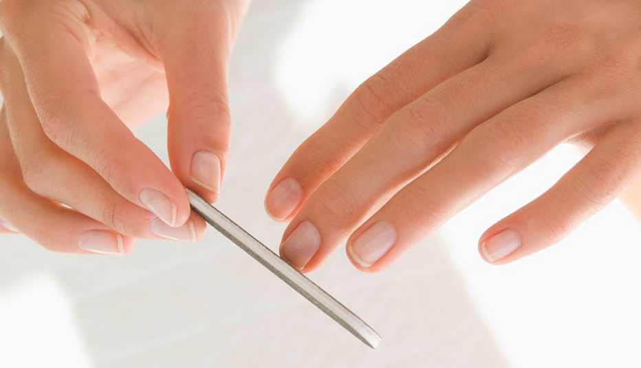 Mujer limándose las uñas.