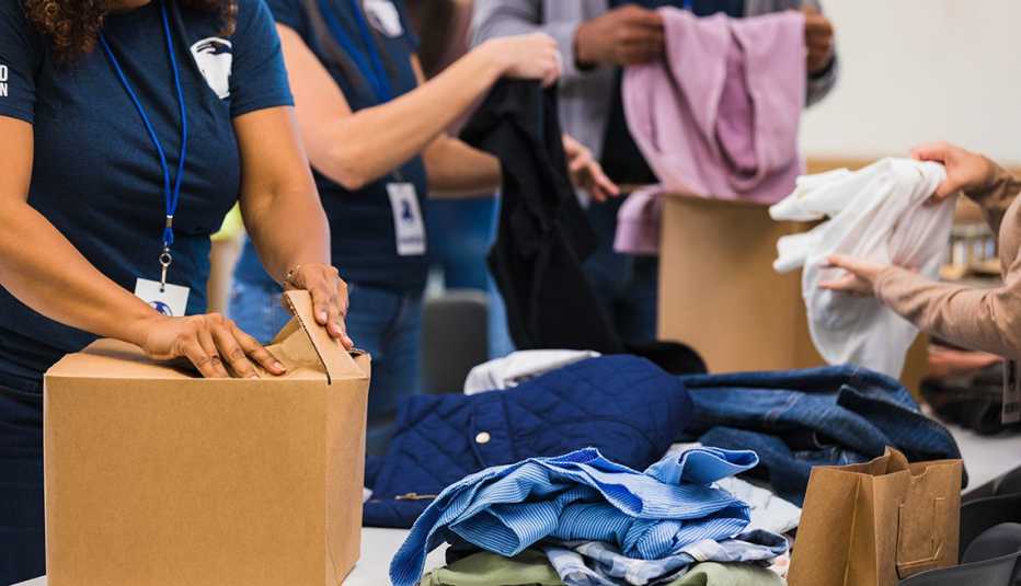 Un grupo de personas revisando ropa donada.