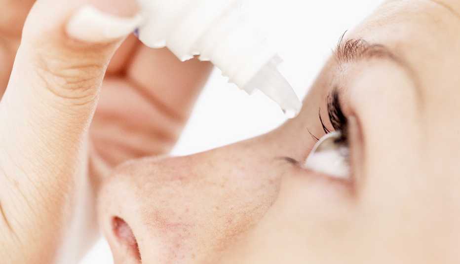 Mujer aplicando gotas para los ojos.