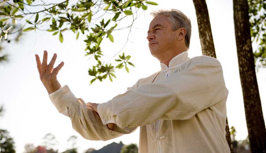 Hombre mayor practicando Tai Chi en un bosque Hombre mayor practicando Tai Chi en un bosque