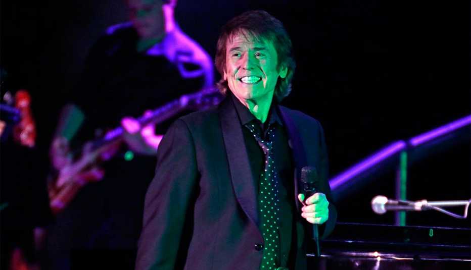 Raphael sonriendo con un micrófono en la mano