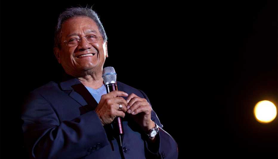 Armando Manzanero sonriendo con un micrófono en la mano