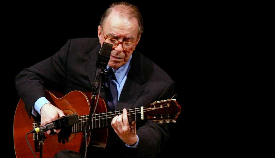 Joao Gilberto en un escenario con una guitarra. Joao Gilberto en un escenario con una guitarra.