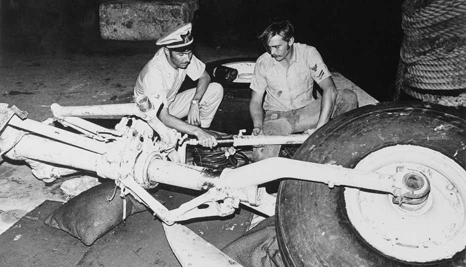 Dos funcionarios inspeccionan los restos del avión que que transportaba a Roberto Clemente y otras cuatro personas que se estrelló en el Océano Atlántico frente a las costas de Puerto Rico.