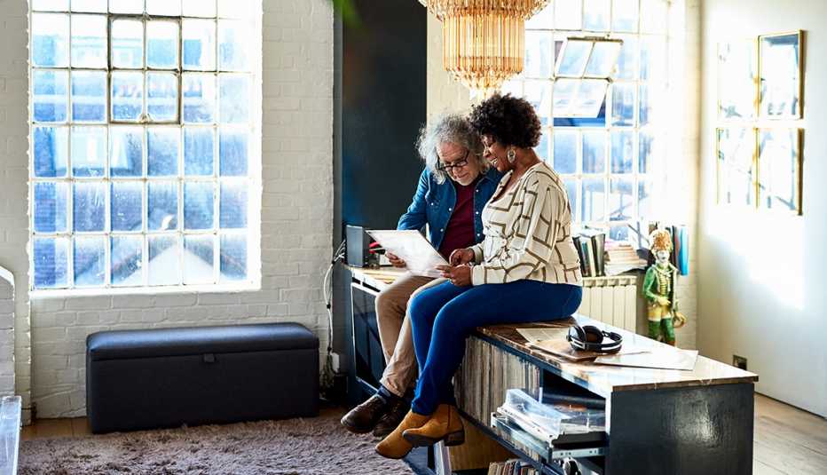 Una pareja sentada mirando portadas de discos.