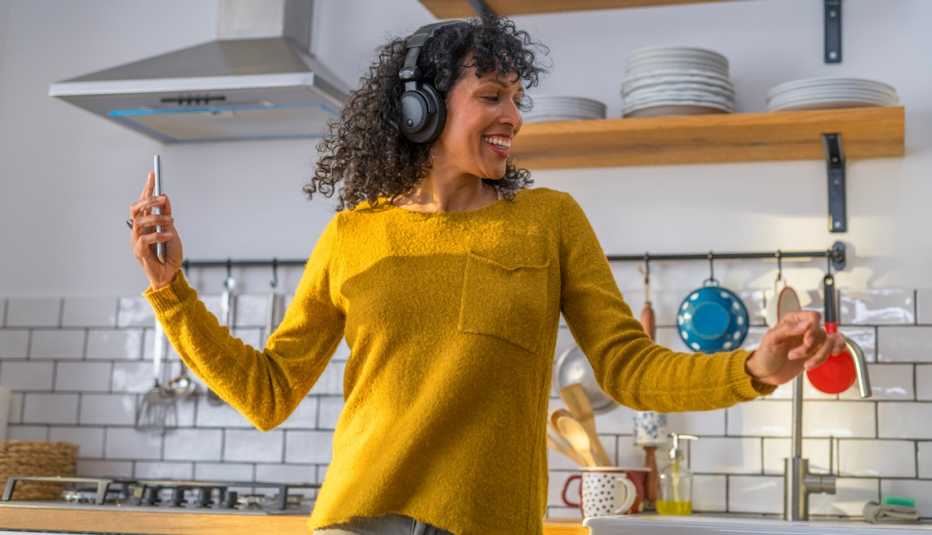 Una mujer bailando mientras escucha música desde su celular.