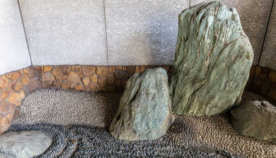 Jardín zen hecho con rocas en el rincón exterior de una casa.