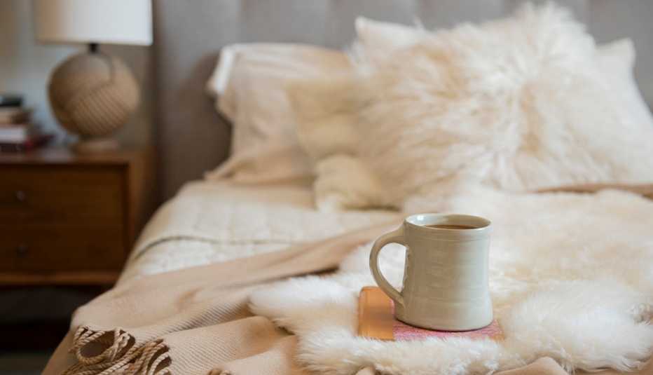 Taza de café y libro sobre una cama Taza de café y libro sobre una cama