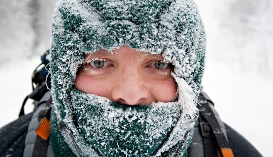 Toma cercana de un hombre bien abrigado y cubierto de nieve