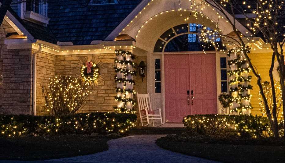Puerta principal decorada con guirnaldas luces y coronas de flores