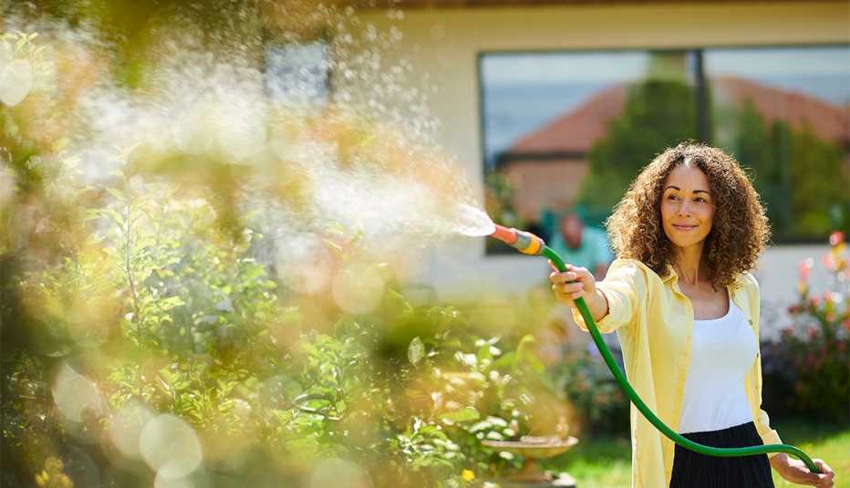 Mujer riega el jardín