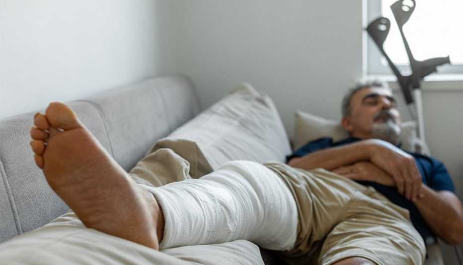 Hombre acostado después de una cirugía de rodilla Hombre acostado después de una cirugía de rodilla