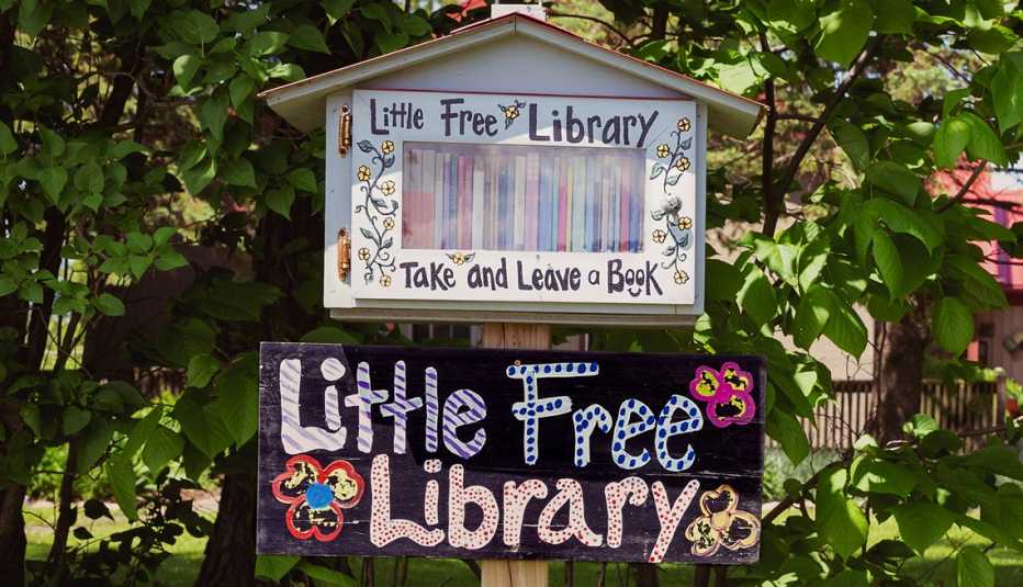 Una casita pequeña llena de libros y letrero que dice Biblioteca gratis Una casita pequeña llena de libros y letrero que dice Biblioteca gratis