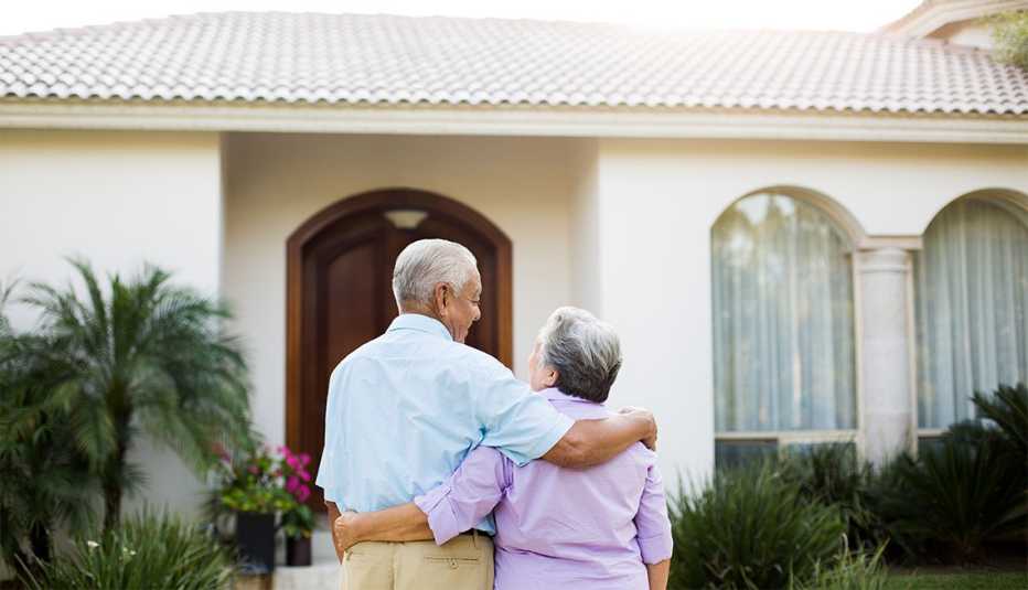 Pareja de adultos mayores camina hacia su casa