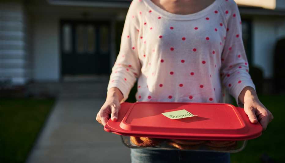 Mujer lleva un recipiente con comida