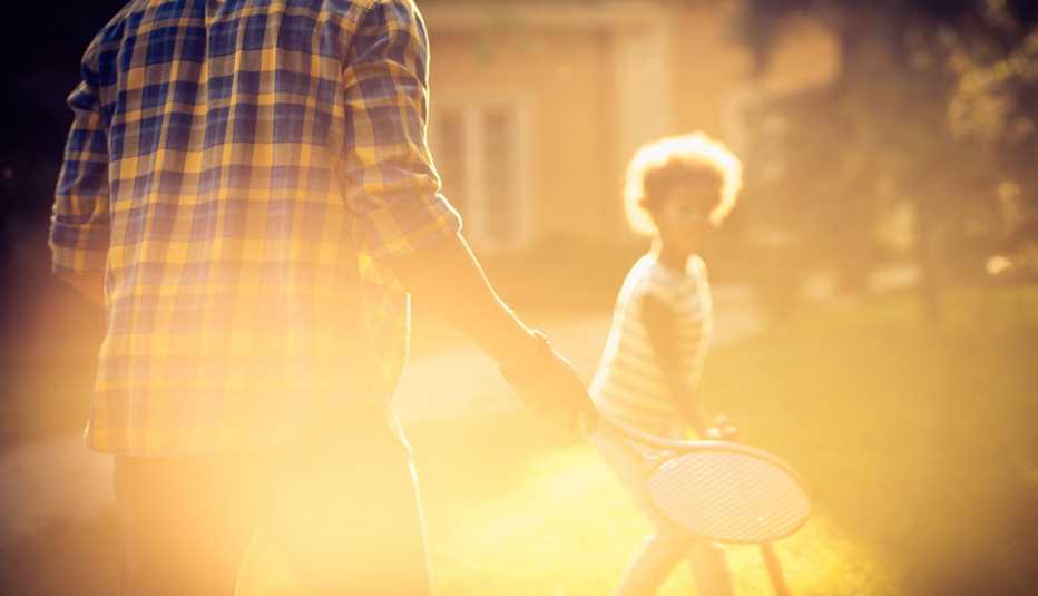 Un hombre y una niña jugando con raquetas