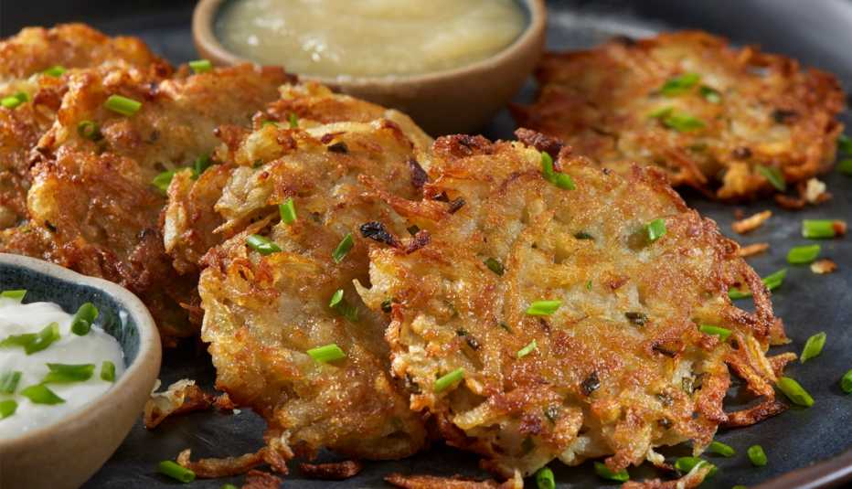 Latkes servidos con crema agria y compota de manzana