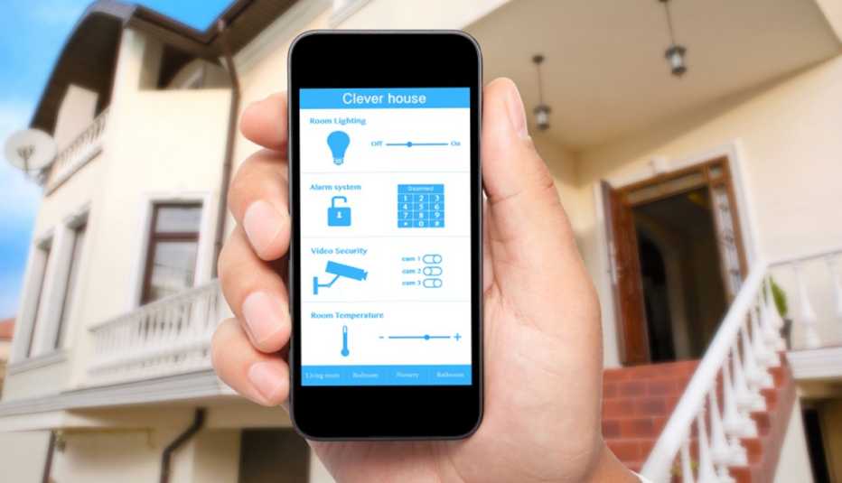Man Holding Smartphone With App That Controls His House, AARP Home And Family, Personal Technology, Connected Homes Man Holding Smartphone With App That Controls His House, AARP Home And Family, Personal Technology, Connected Homes