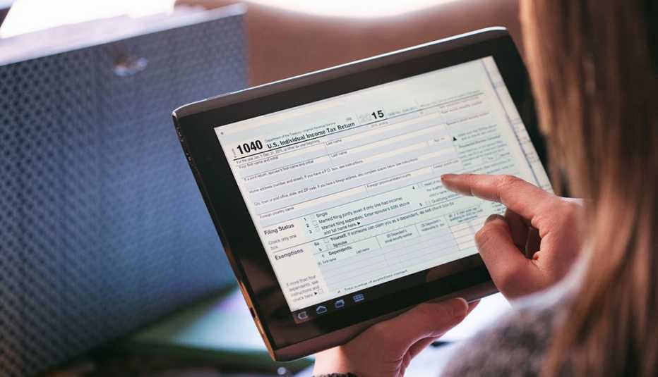 Mujer diligencia sus impuestos en una tableta digital Mujer diligencia sus impuestos en una tableta digital
