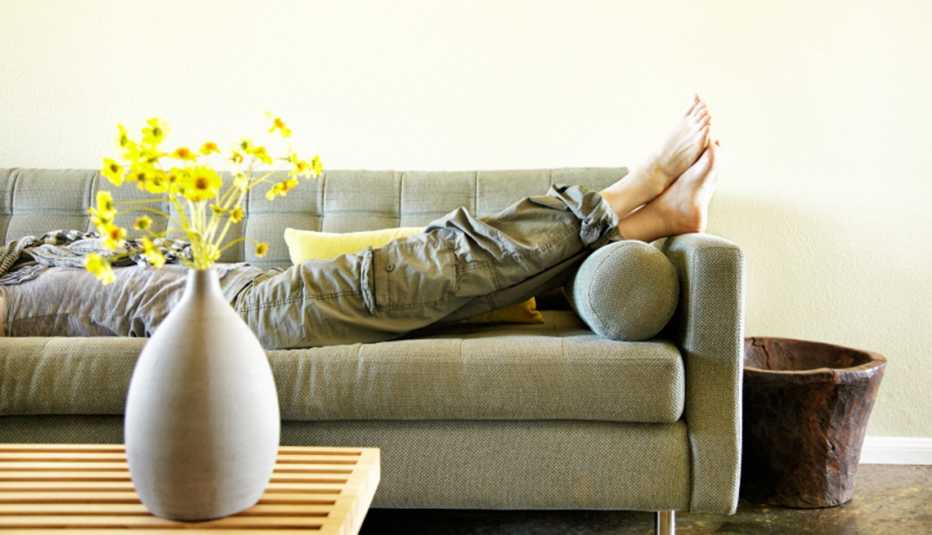 Woman Lying On Sofa In Her Home, AARP Home And Family, Home Improvement, How To Apply Feng Shui Woman Lying On Sofa In Her Home, AARP Home And Family, Home Improvement, How To Apply Feng Shui