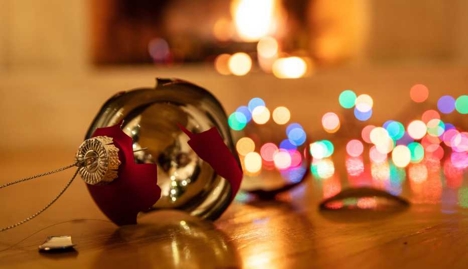 Adorno de navidad roto y al fondo luces decorativas