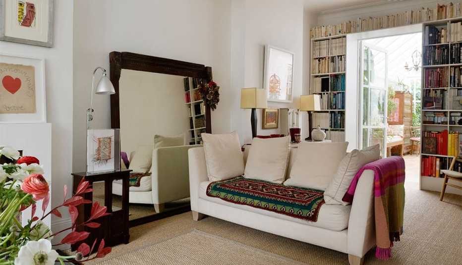 Un espejo grande  reflejando un sillón en una sala de estar